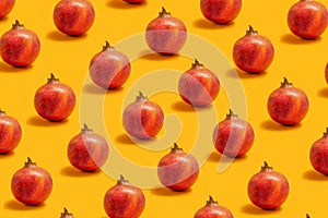Juicy mediterranean fruit concept. Pattern made of many organicÃÂ fresh pomegranate fruits against a pastelÃÂ orange background photo